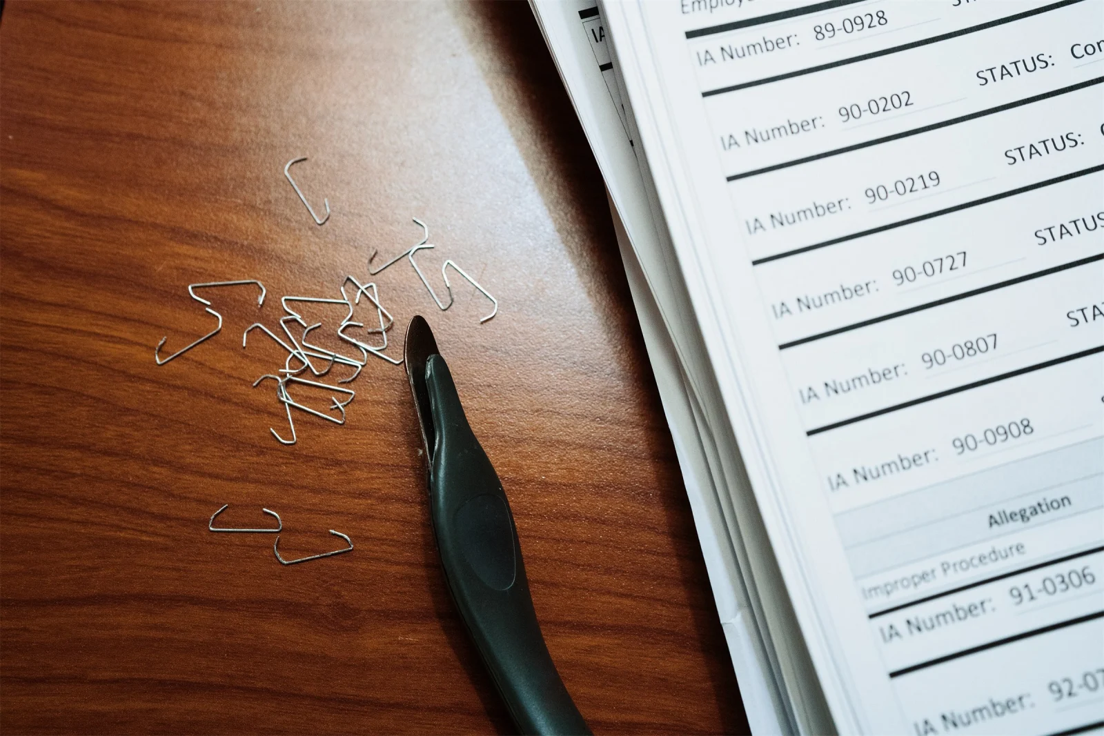 Une pile de documents papier, des agrafes et un ôte-agrafes sur une table