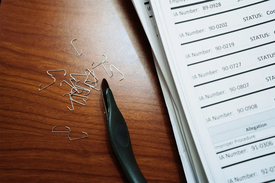 Une pile de documents papier, des agrafes et un ôte-agrafes sur une table