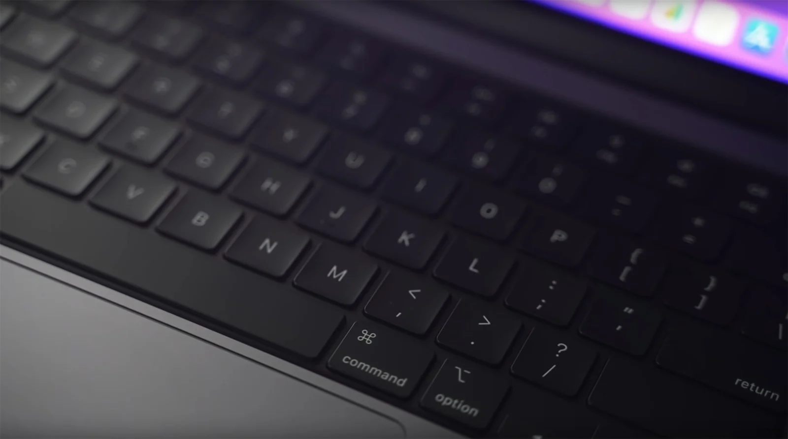 Gros plan sur le clavier rétroéclairé d'un MacBook Pro 14 pouces, touches command et option au premier plan